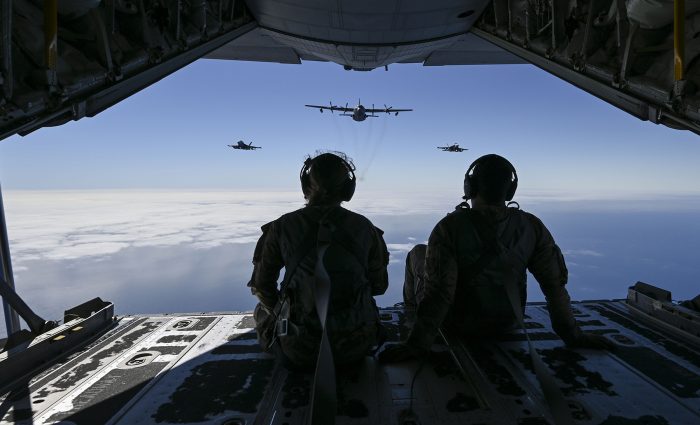 U.S. Air Force 2nd Lt. Ella Furlong, left, 418th Test and Evaluation Squadron flight test analyst, and Tech. Sgt. Austin Temple, 418th TES loadmaster, watches two Navy EA-18G Growler aircraft fly in formation with an EC-130H Compass Call aircraft during Gray Flag 24, off the coast of California, Sept. 25, 2024. All three aircraft possess advanced electronic jamming capabilities and are vital for modern combat. (U.S. Air Force photo by Senior Airman Paige Weldon)